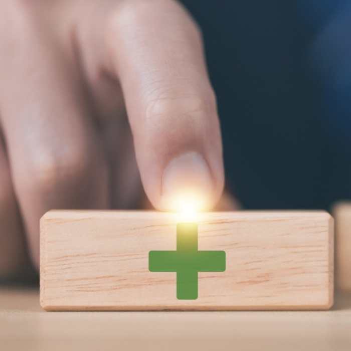 wooden block shows plus symbols. The concept of positive decisions/advantages